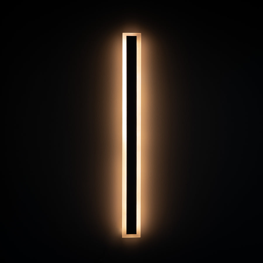 An outdoor minimal linear wall lamp emitting a warm light 
